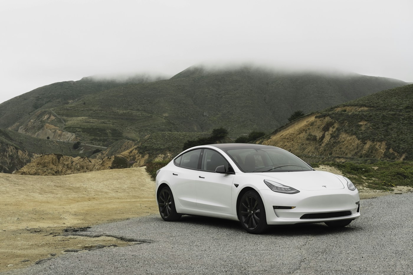 Tesla Model 3 eléctrico en una carretera junto a las montañas